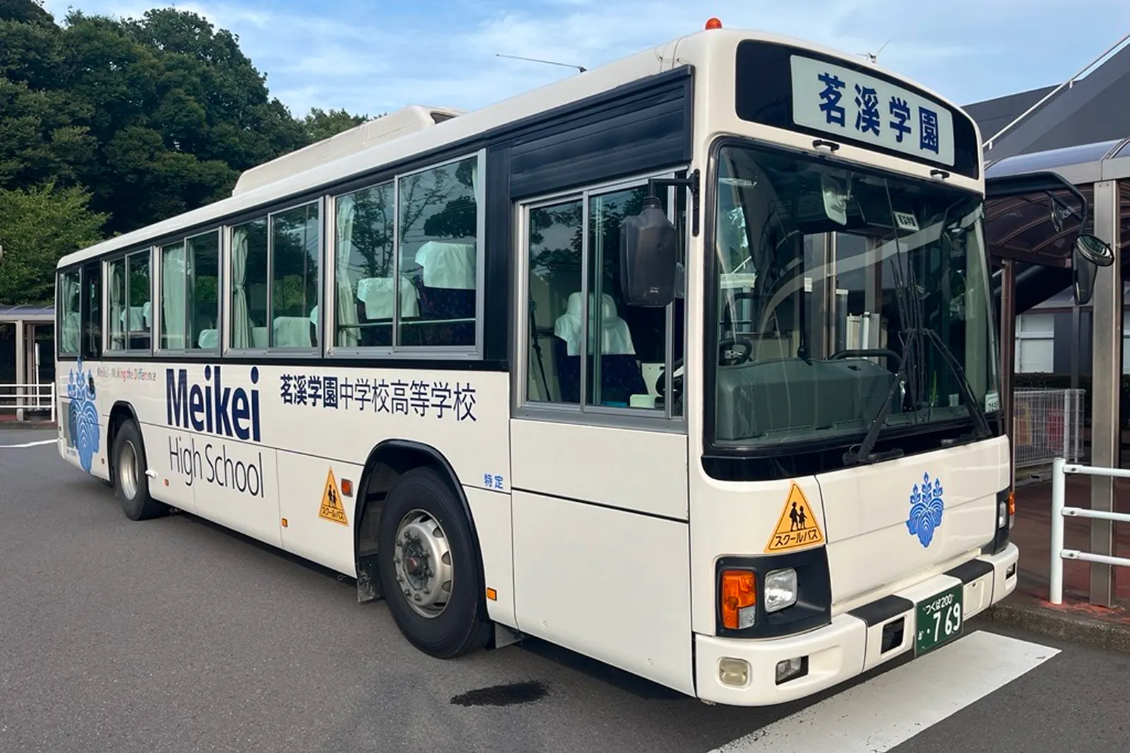 '茗溪学園' 행선지 표시와 'Meikei High School' 글자가 들어간 흰색 메이케이가쿠엔 고등학교 스쿨버스