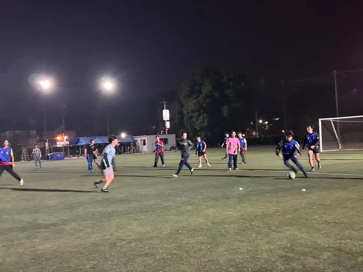 야간 조명 아래 운동장에서 축구를 하는 기숙사생들
