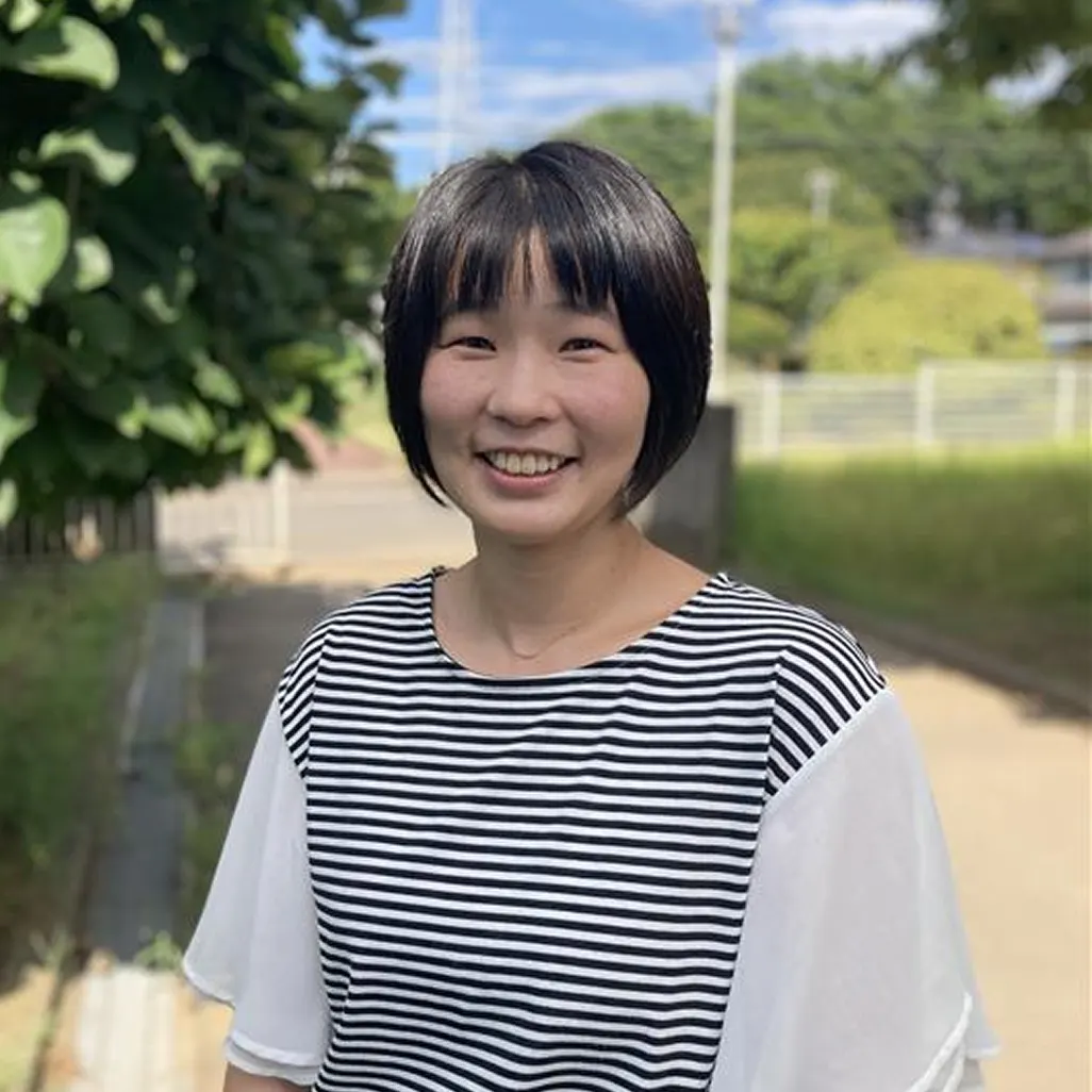 나무가 있는 길을 배경으로 웃고 있는 하우스마스터 고토 사유리