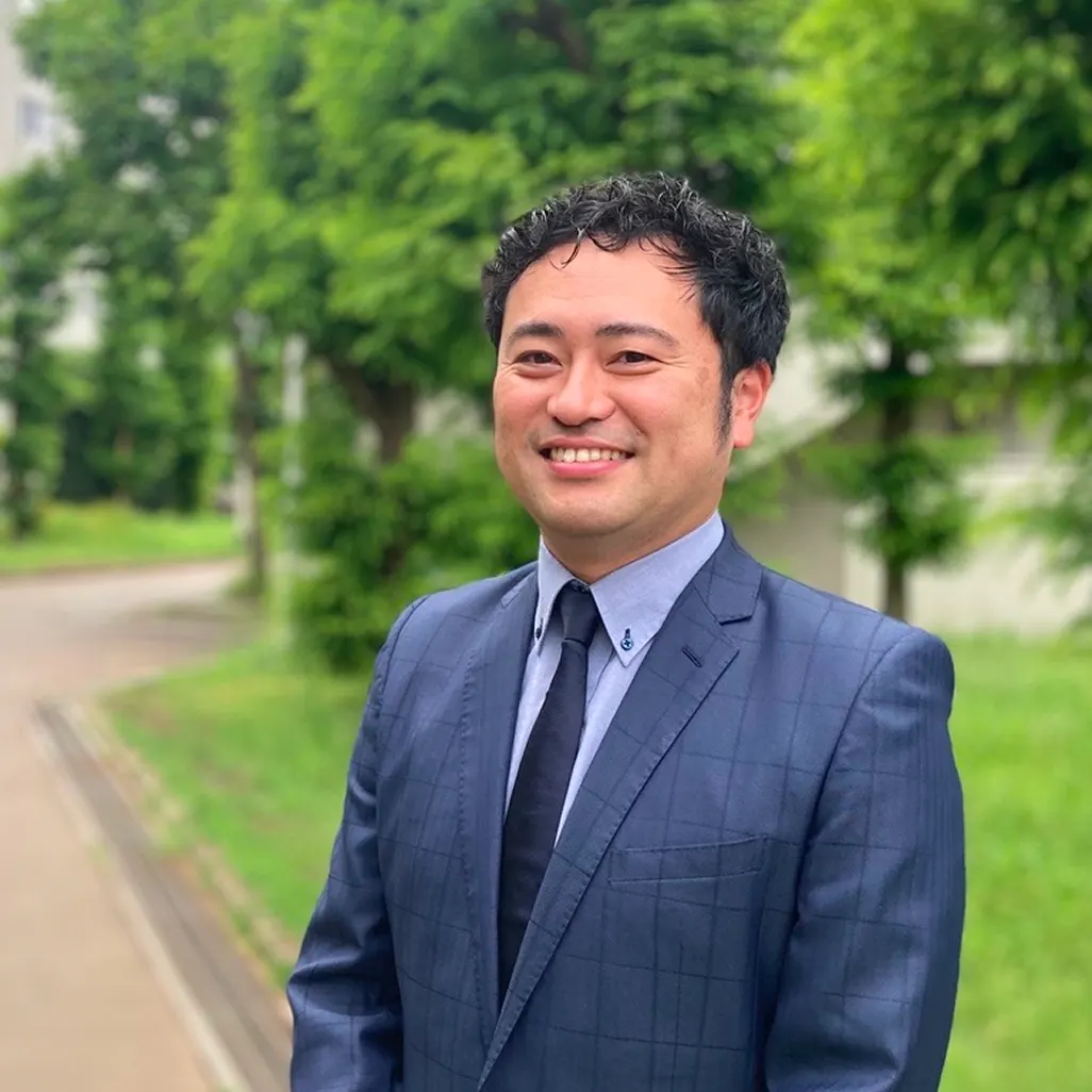 정장 차림으로 웃고 있는 기숙사장 구라모치