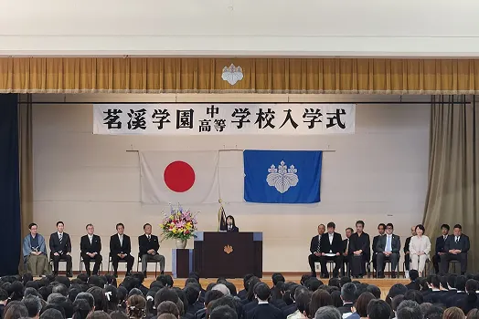 '茗溪学園中学校高等学校入学式' 현수막이 걸린 강당에서 열리는 입학식
