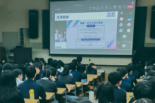 대형 스크린에 '生徒総会' 화면을 띄우고 강의실에 모인 학생들