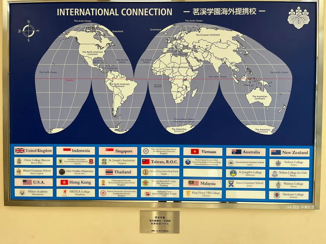 'INTERNATIONAL CONNECTION 茗溪学園海外提携校' 제목의 세계 지도 아래 나라별 해외 제휴교 이름판이 붙은 교내 패널