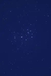 푸른 밤하늘에 밝은 별들이 모여 있는 플레이아데스 성단