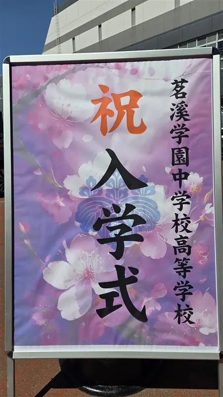 벚꽃 그림 위에 축 입학식, 메이케이가쿠엔 중학교 고등학교라고 쓴 입간판