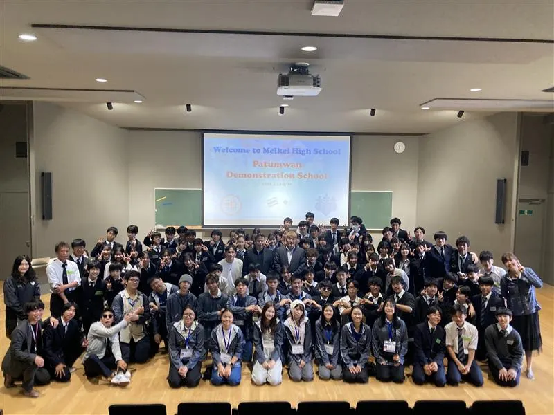 Welcome to Meikei High School, Patumwan Demonstration School 환영 화면 앞에 모인 두 학교 학생과 교사들의 단체 사진