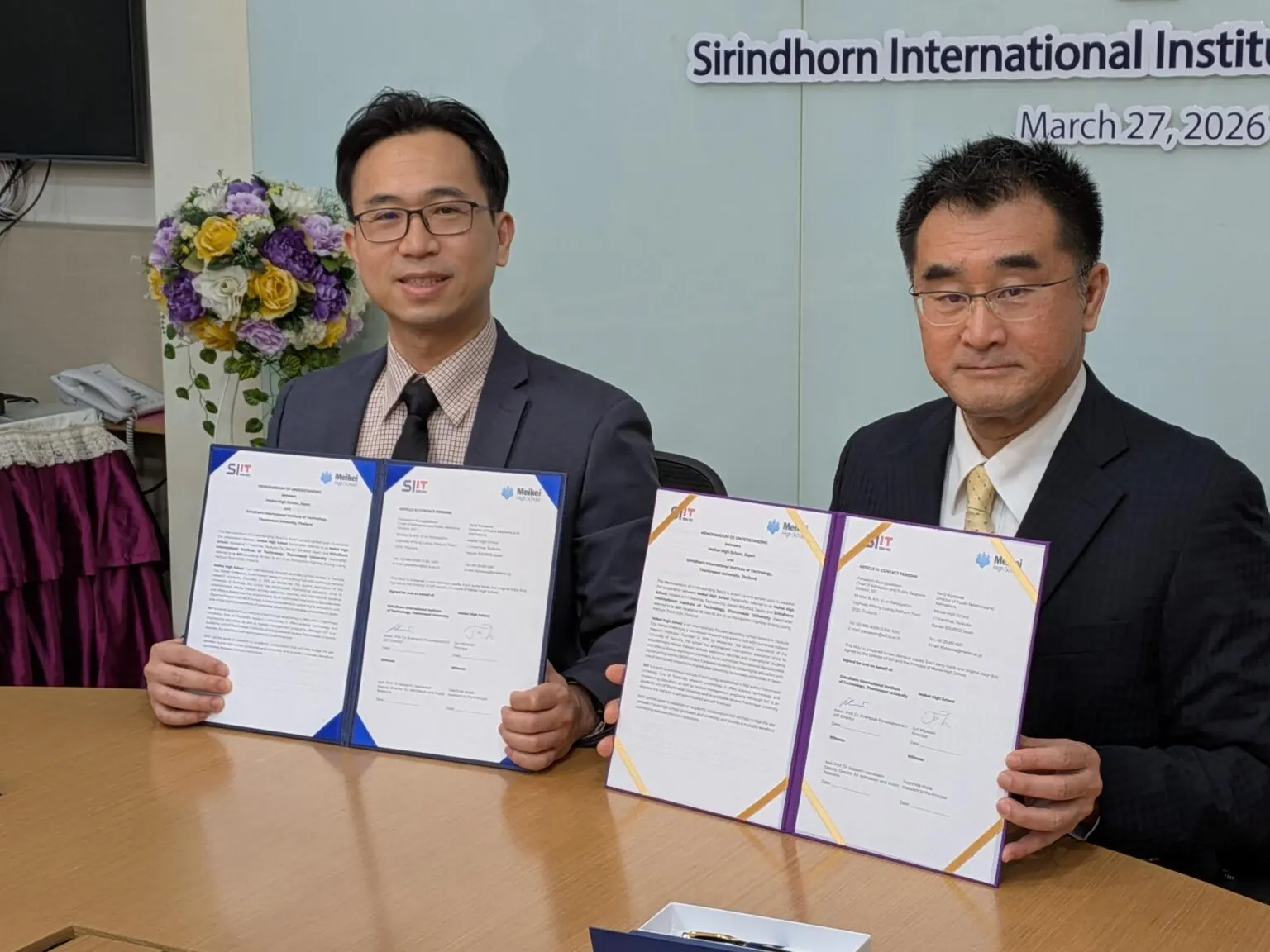 서명을 마친 양해각서(Memorandum of Understanding)를 펼쳐 들고 있는 시린톤 국제공학부 대표와 메이케이가쿠엔 고등학교 대표