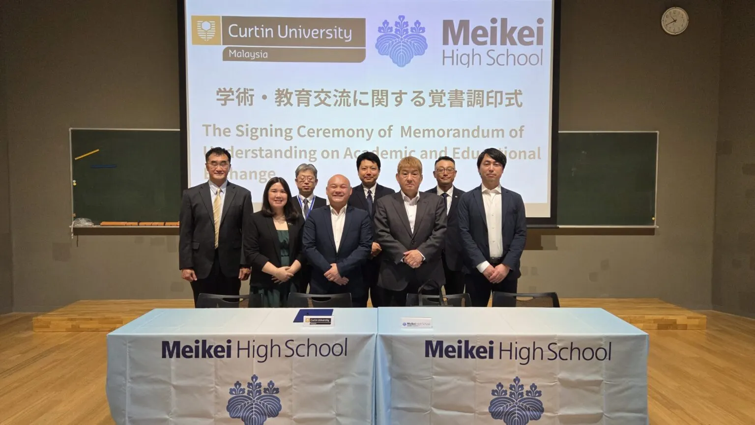 Curtin University Malaysia와의 각서 조인식을 마치고 Meikei High School 테이블 뒤에 선 양측 관계자 단체 사진