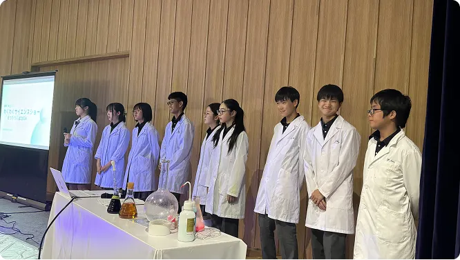 흰 가운을 입고 실험 도구 앞에 선 과학부 화학반 학생들