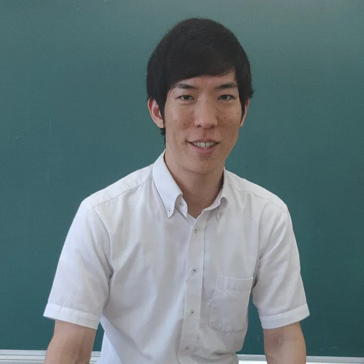 칠판 앞에 앉아 웃는 영어과 교원