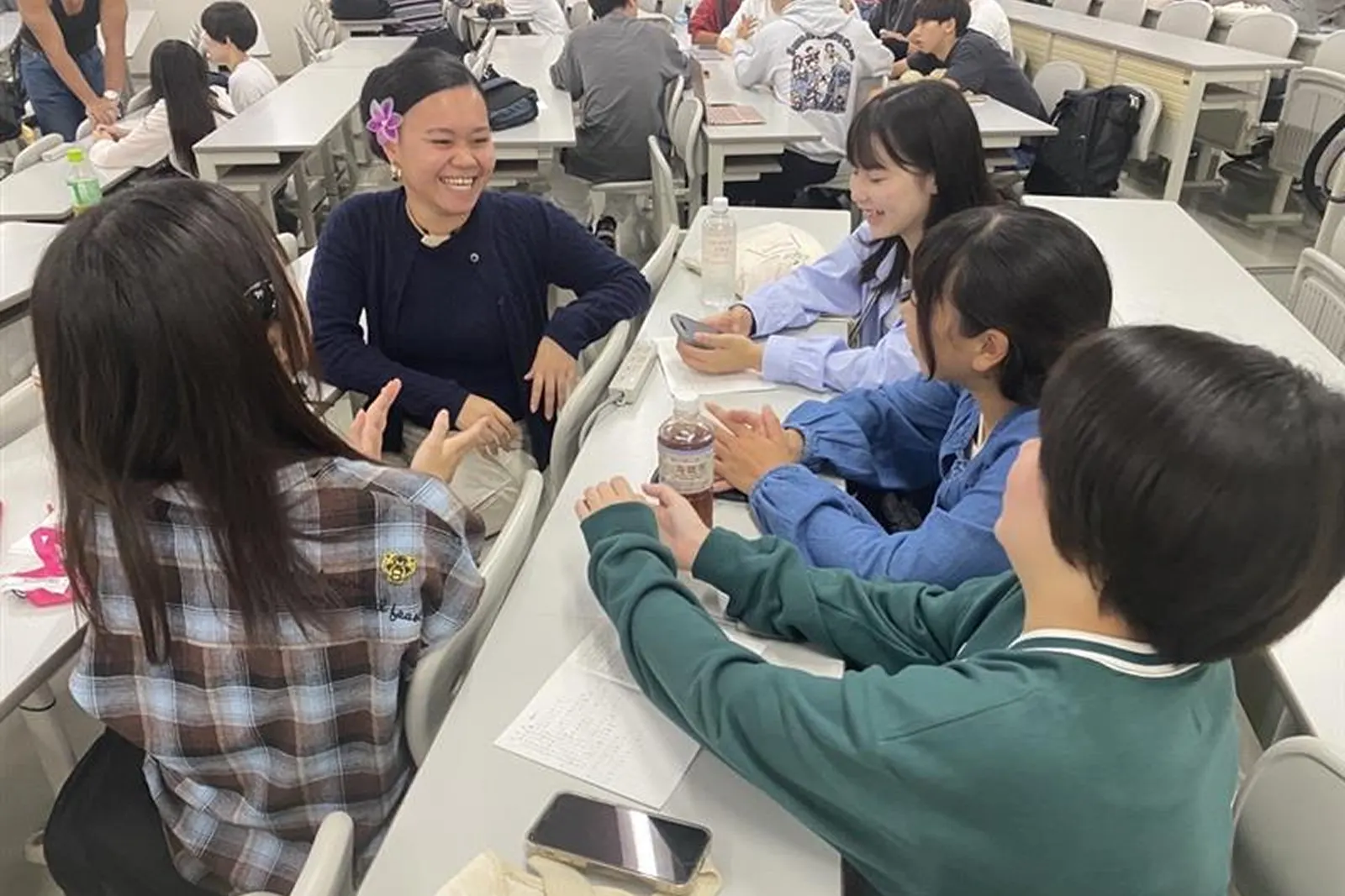 대학 강의실에서 국제 학생과 이야기를 나누는 학생들