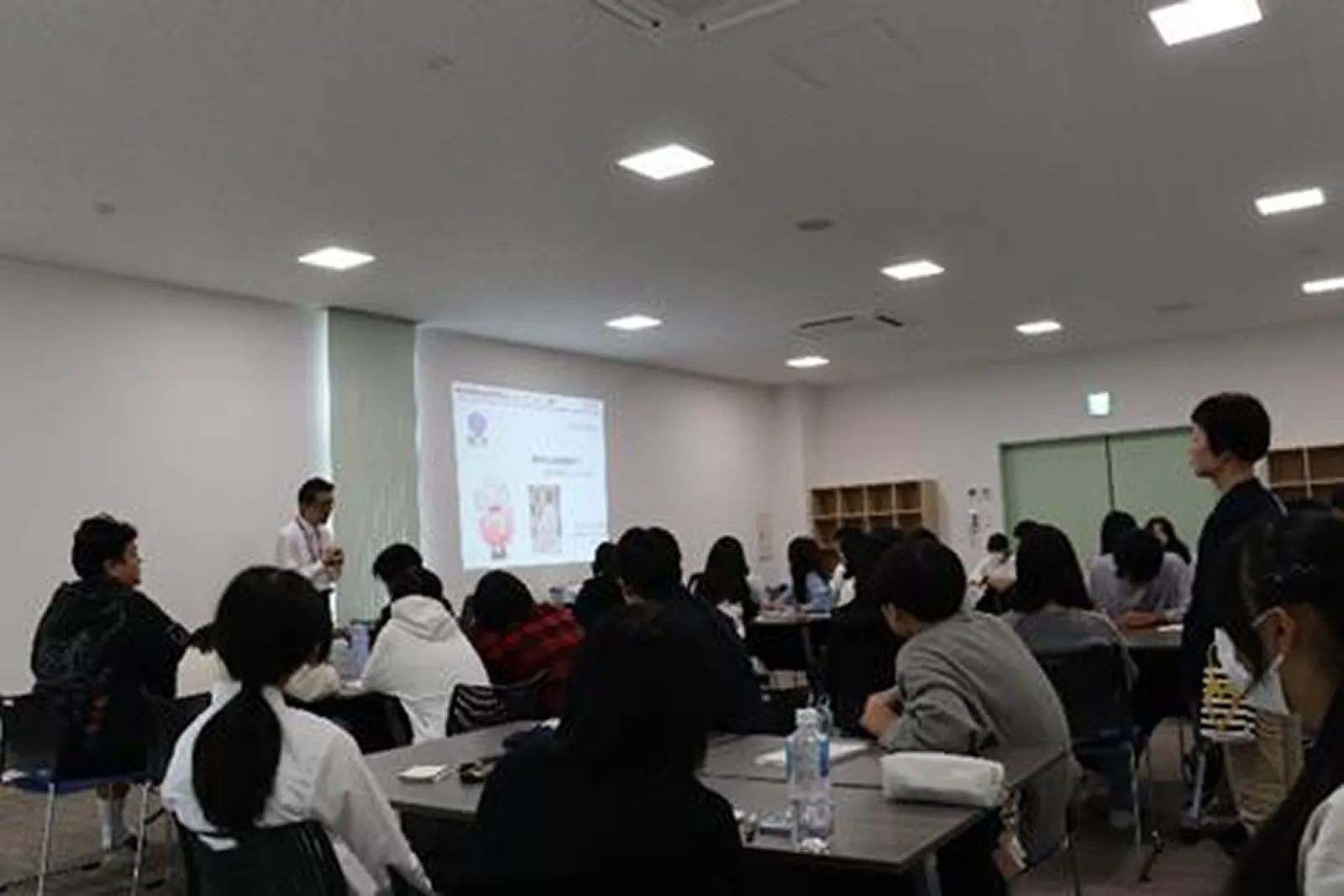 강의실에서 화면을 보며 강연을 듣는 학생들